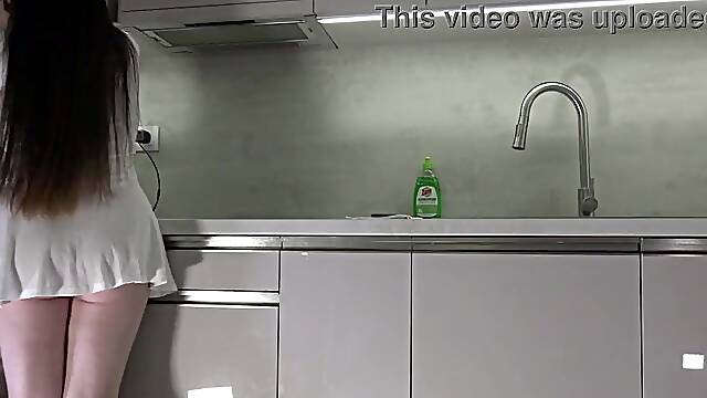 Fresh wife sexy brunette hair honey with large breasts large booty in the kitchen with a short white transparent costume shows what that babe has